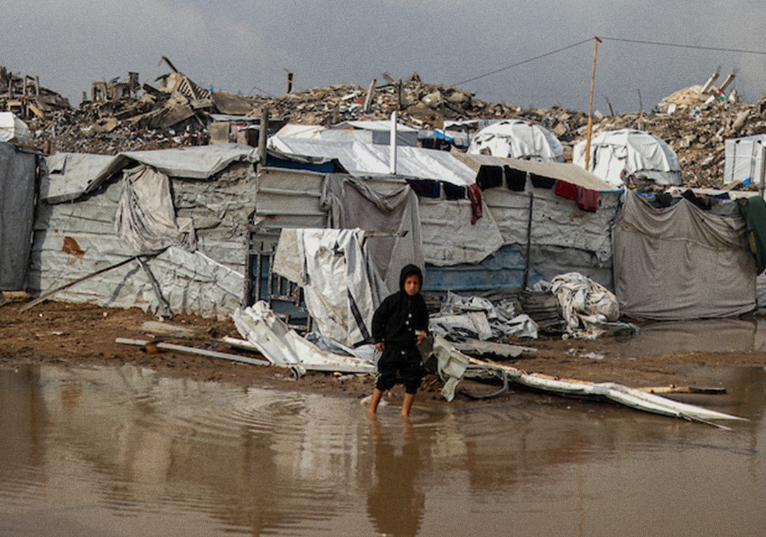 Palestinian child in a pool of water in Gaza during winter