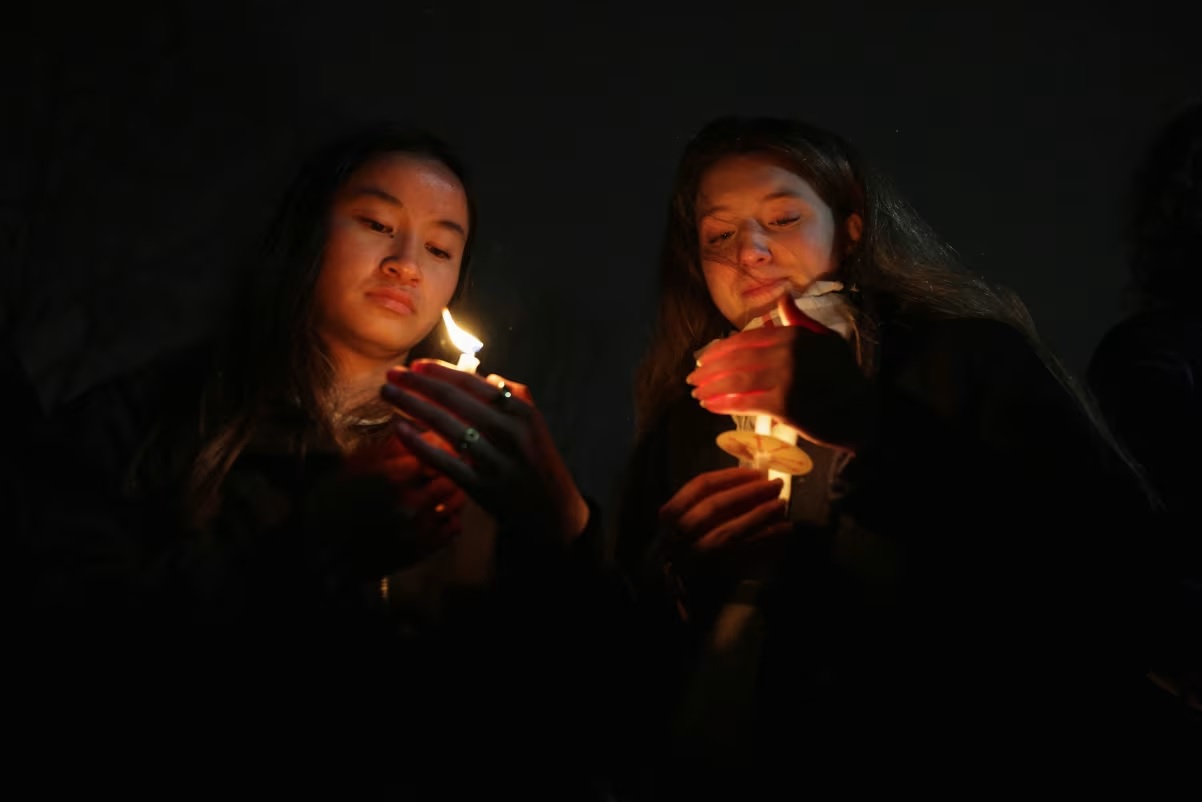 Two students hold candles during a vigil in Providence Rhode Island on Sunday. Taylor Coester Reuters